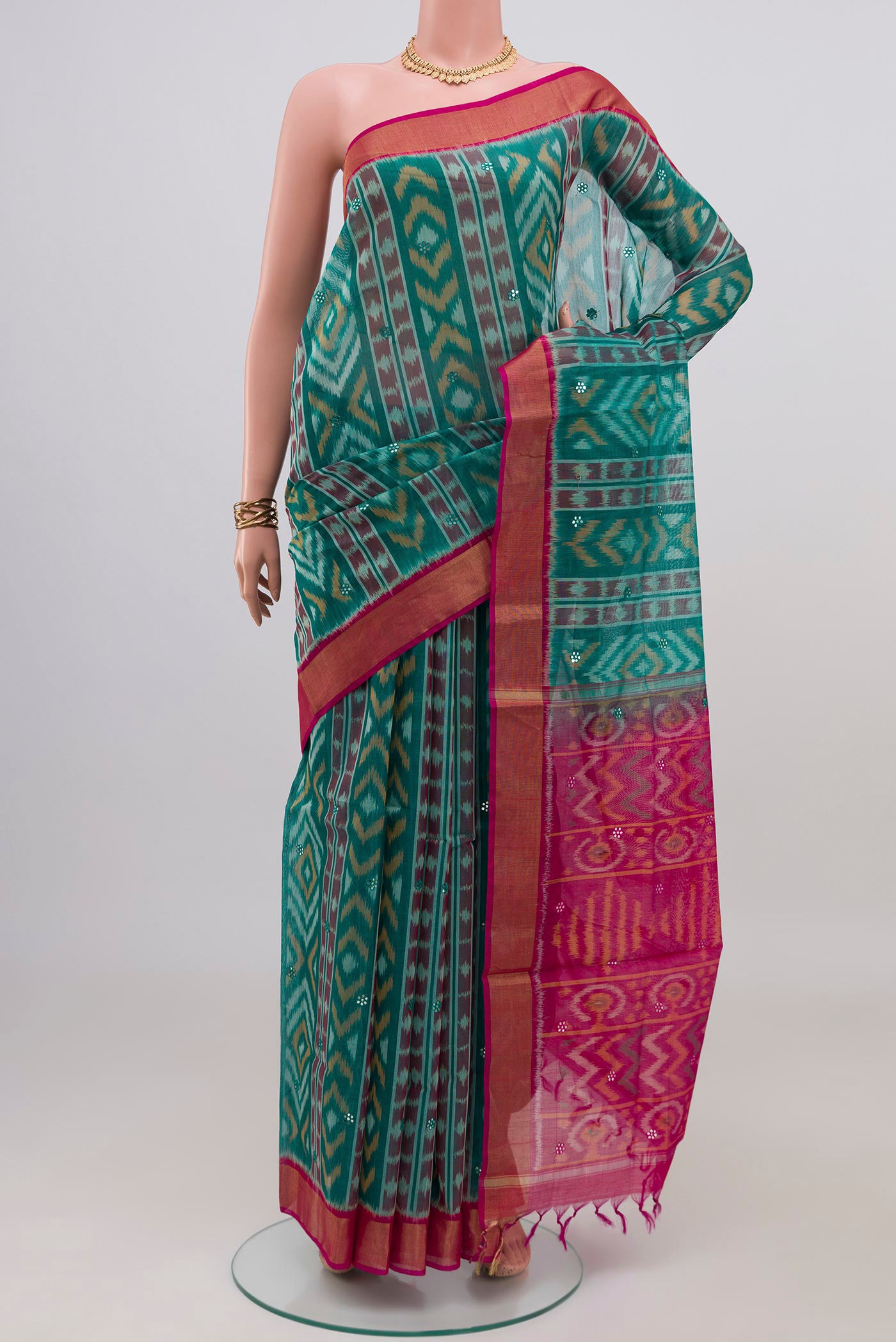 Green Silk Cotton Saree with Ikat design on the body and Zari Border.  displayed on a mannequin