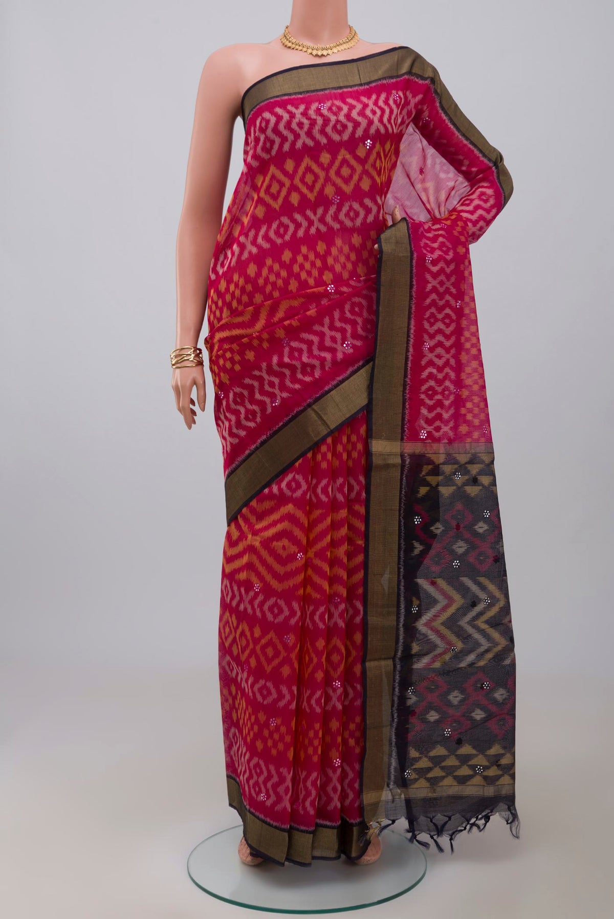 Pink Silk Cotton Saree with Ikat design on the body and Zari Border.  displayed on a mannequin