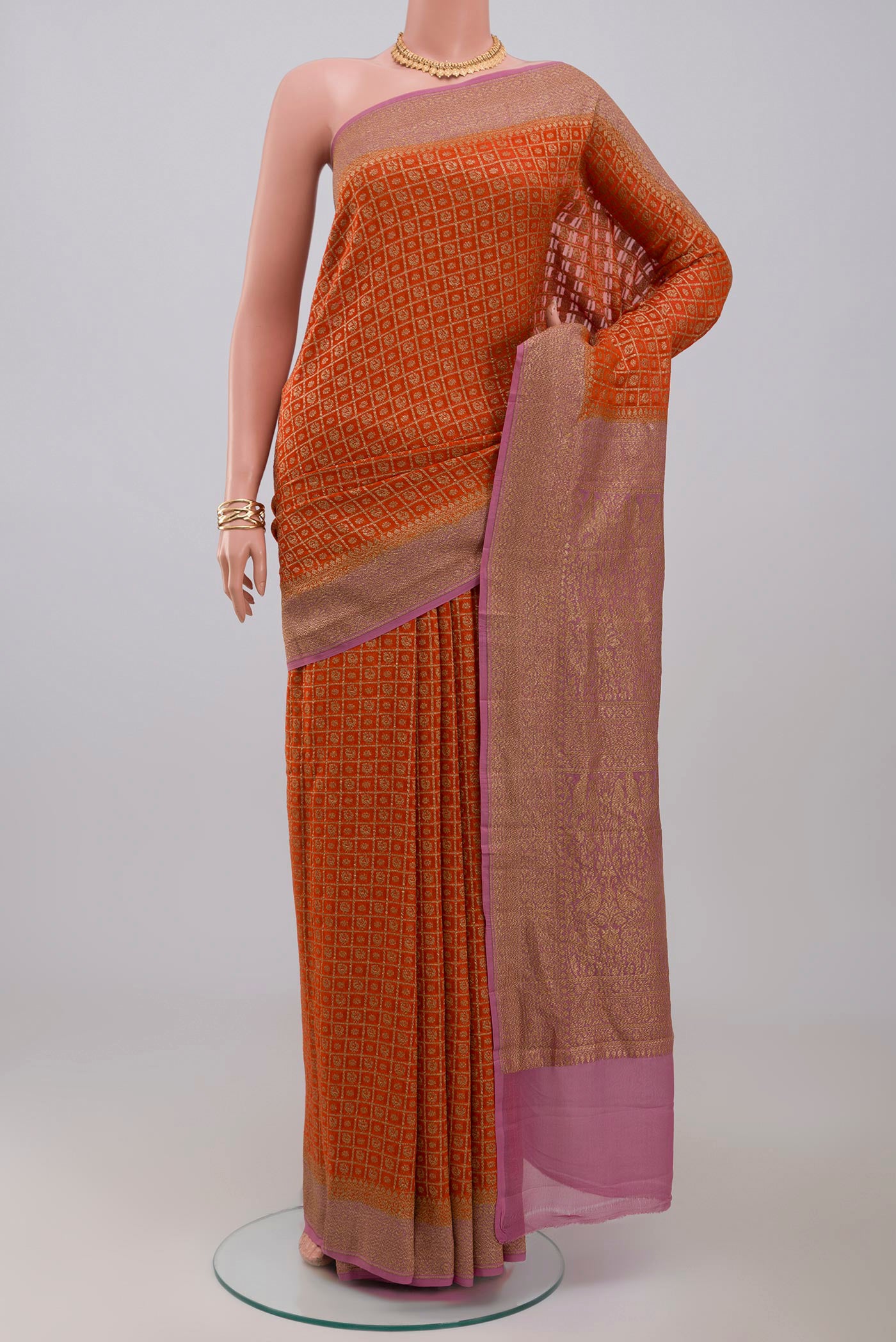 Orange Georgette Saree with Fancy on the body and Zari Border.  displayed on a mannequin