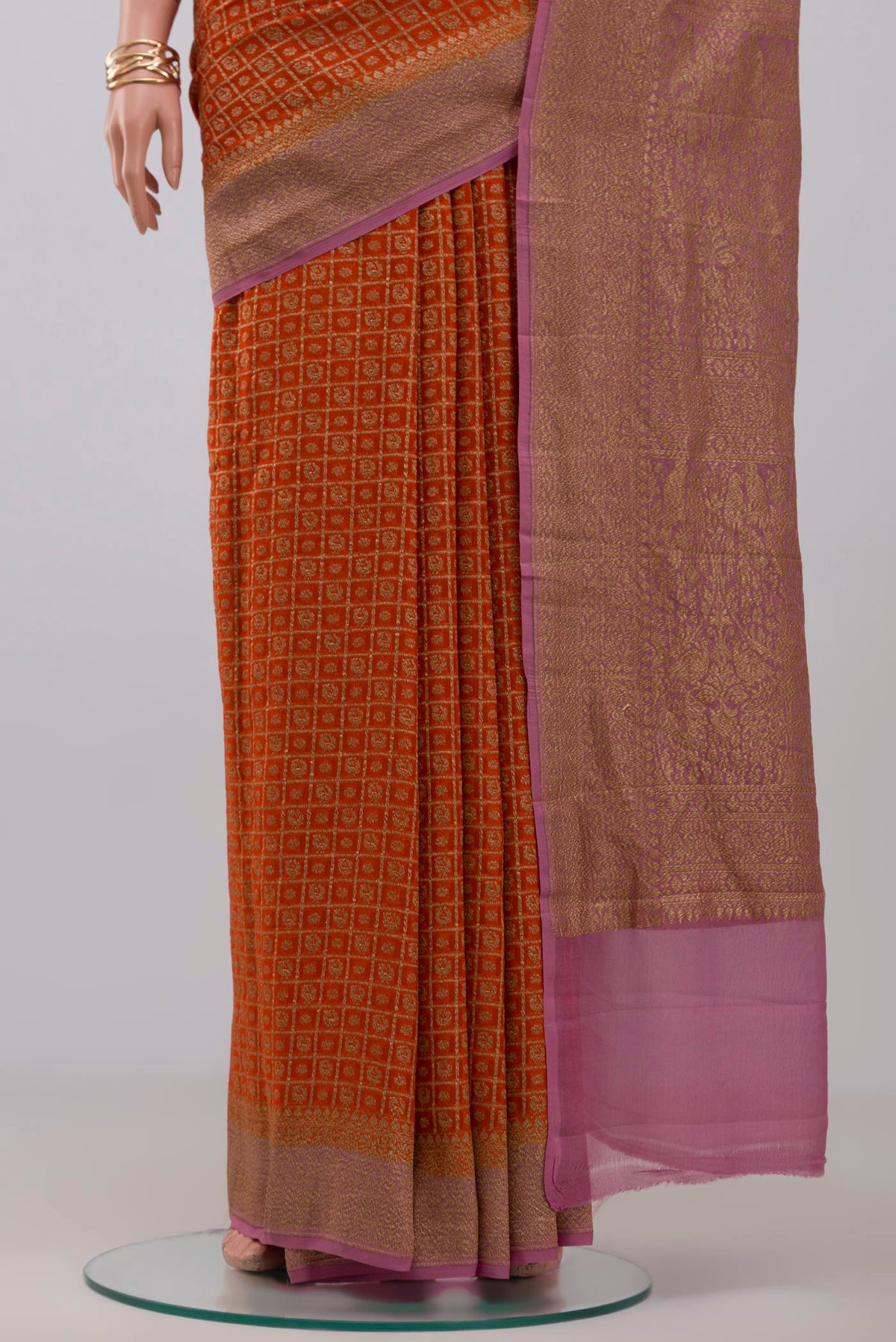 Pleats and pallu of Orange Georgette Saree with Fancy on the body and Zari Border. 