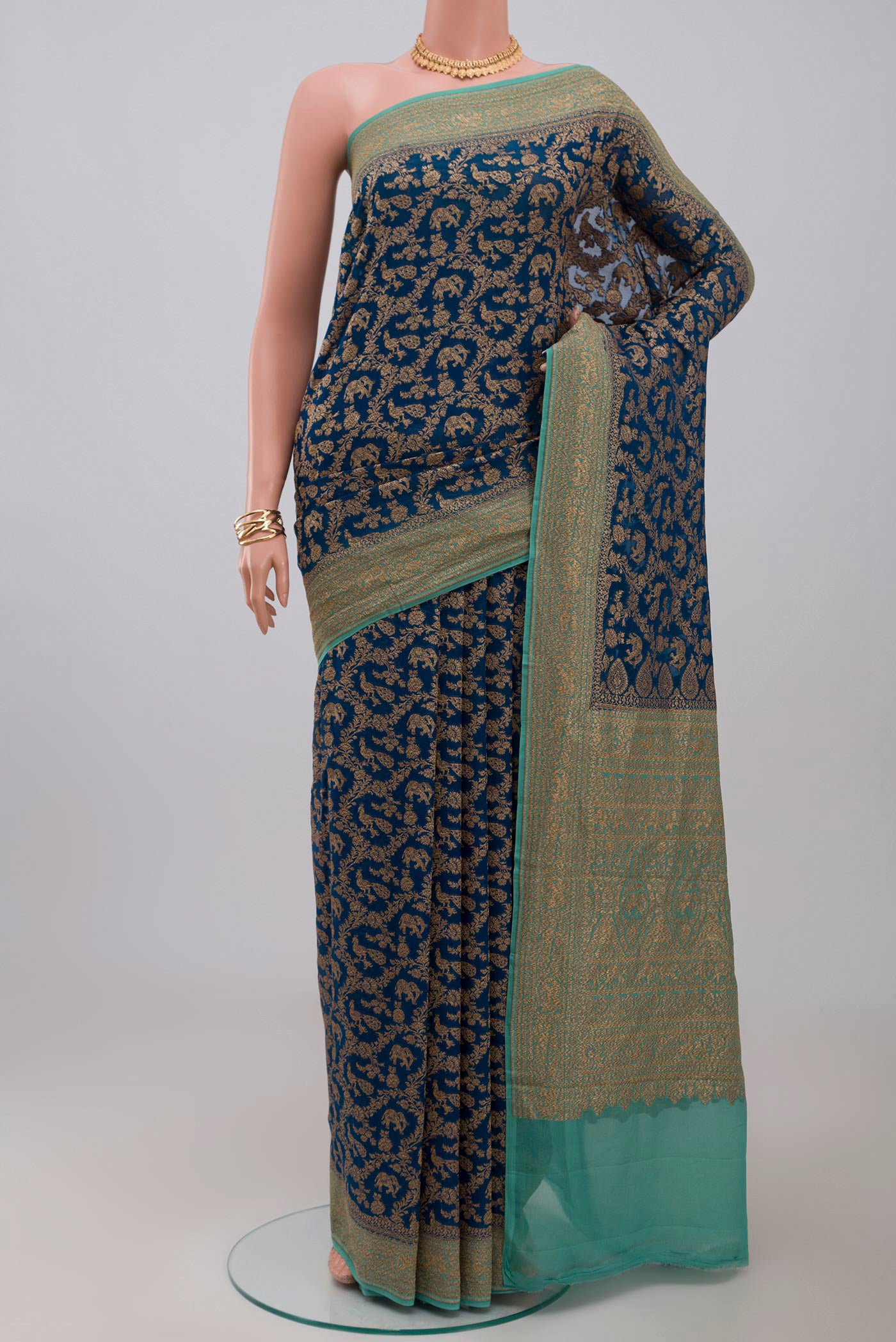 Blue Georgette Saree with Fancy on the body and Zari Border.  displayed on a mannequin