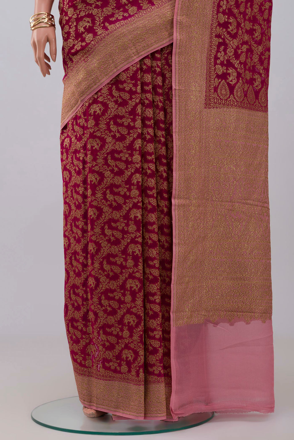 Pleats and pallu of Pink Georgette Saree with Fancy on the body and Zari Border. 