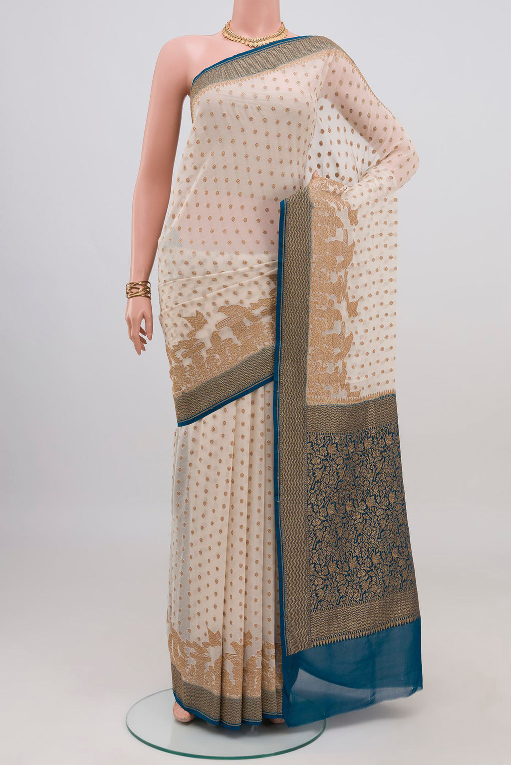 Cream Banarasi Georgette Saree with Zari Butta on the body and Zari Border.  displayed on a mannequin