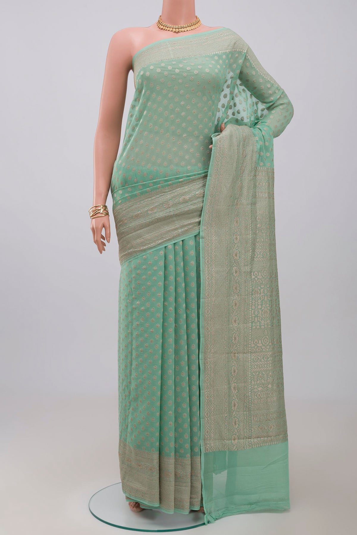 Pista Green Georgette Saree with Fancy on the body and Zari Border.  displayed on a mannequin