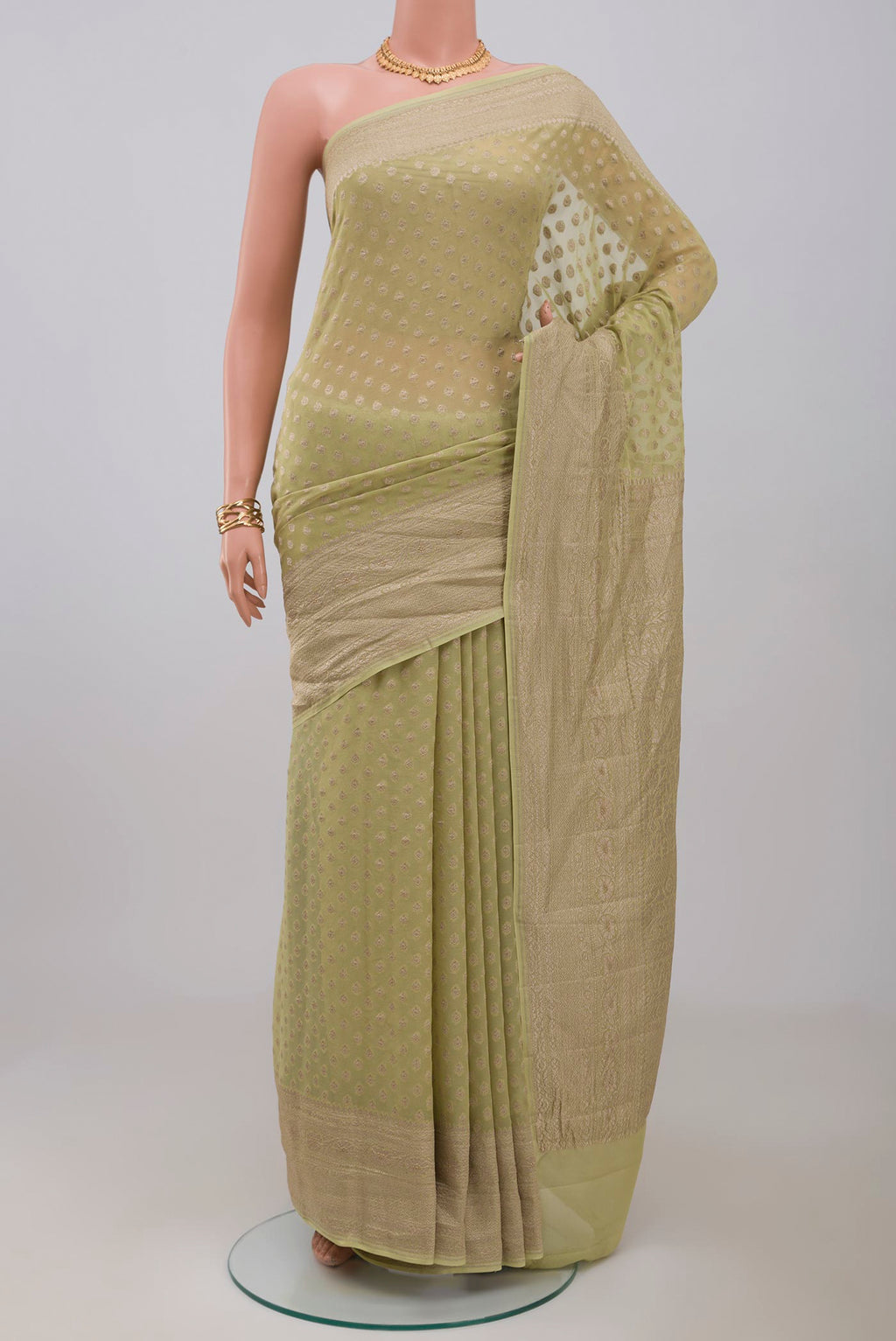 Green Georgette Saree with Fancy on the body and Zari Border.  displayed on a mannequin