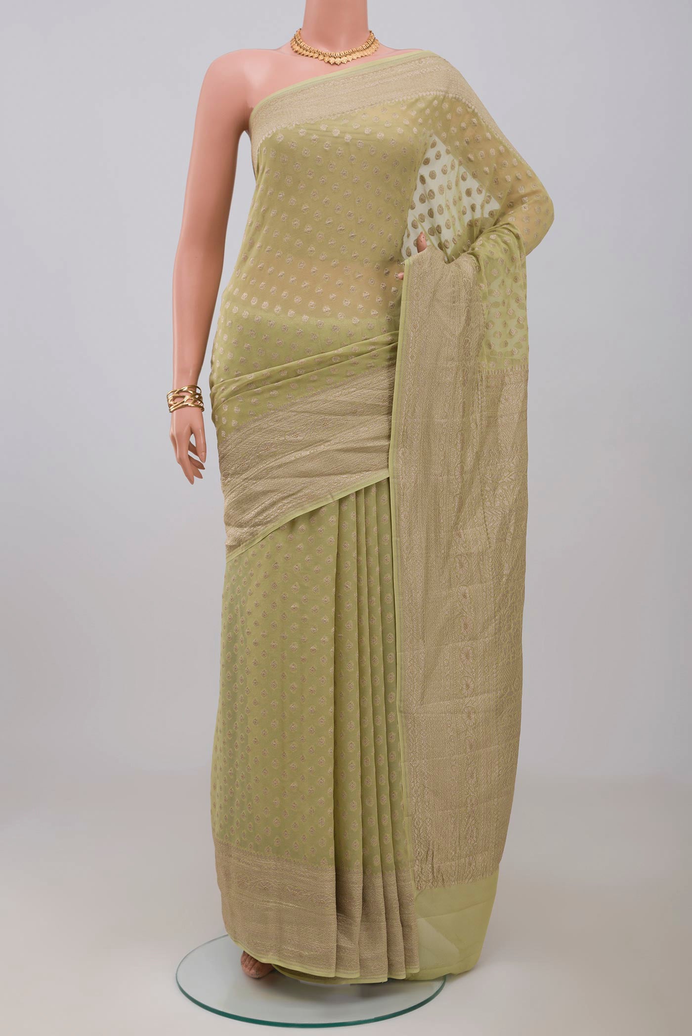 Green Georgette Saree with Fancy on the body and Zari Border.  displayed on a mannequin