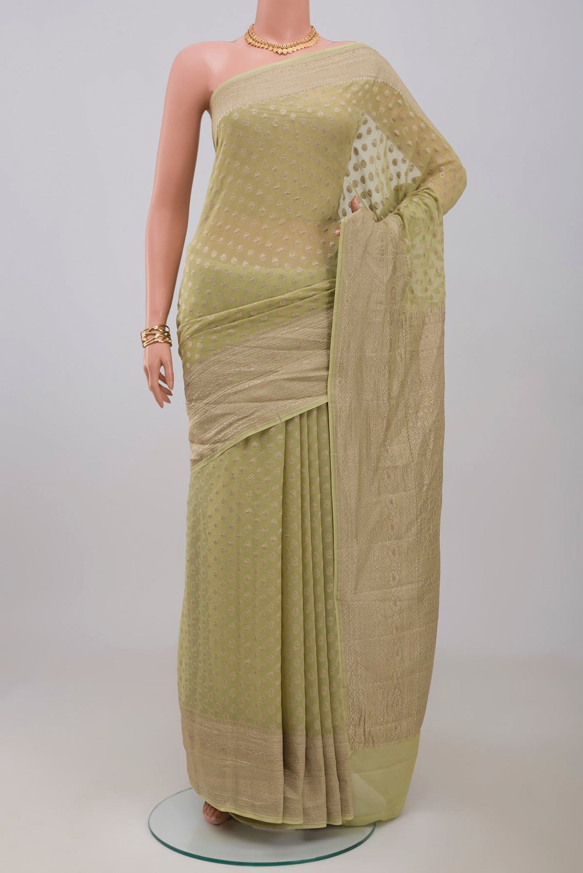 Green Georgette Saree with Fancy on the body and Zari Border.  displayed on a mannequin