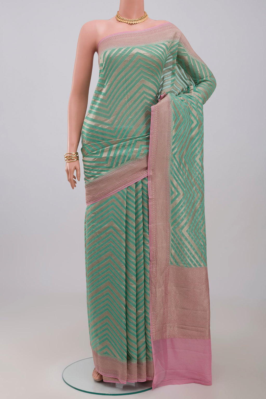 Green Georgette Saree with Fancy on the body and Zari Border.  displayed on a mannequin