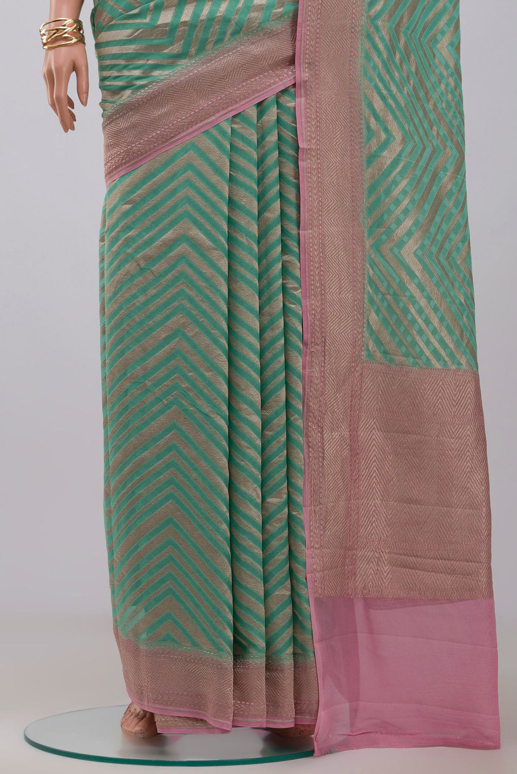 Pleats and pallu of Green Georgette Saree with Fancy on the body and Zari Border. 