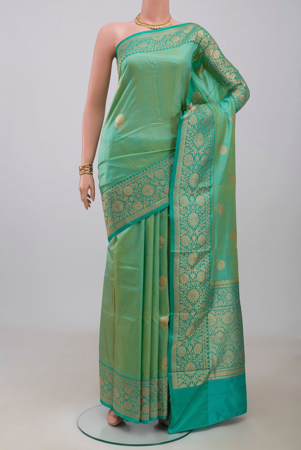 Light Green Banarasi Katan Silk Saree with Zari Butta on the body and Zari Border.  displayed on a mannequin