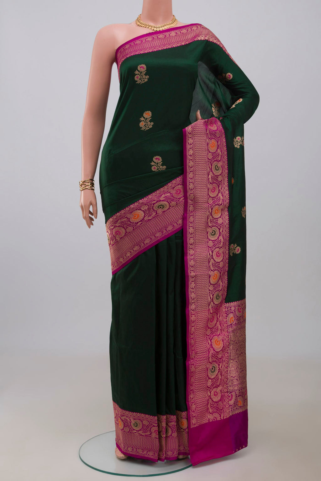 Bottle Green Banarasi Katan Silk Saree with Zari Butta on the body and Fancy Border.  displayed on a mannequin