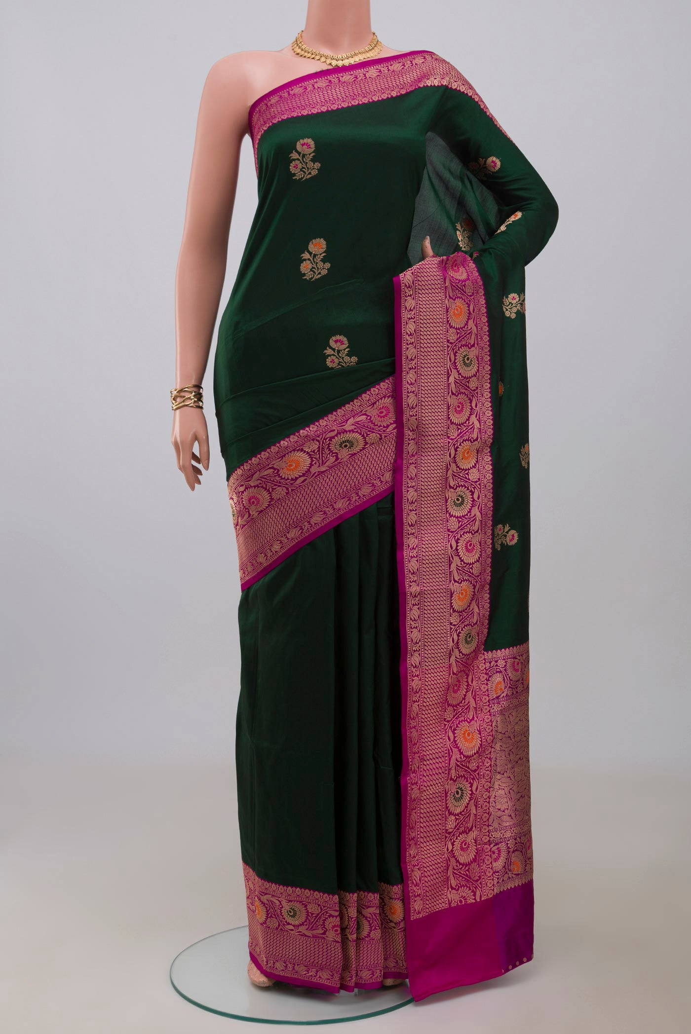 Bottle Green Banarasi Katan Silk Saree with Zari Butta on the body and Fancy Border.  displayed on a mannequin