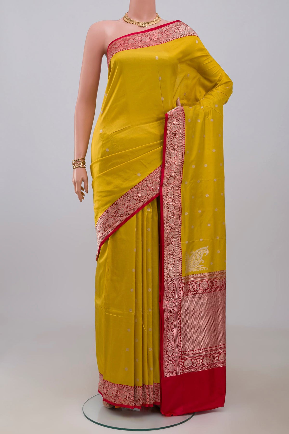 Yellow Banarasi Katan Silk Saree with Zari Butta on the body and Zari Border.  displayed on a mannequin