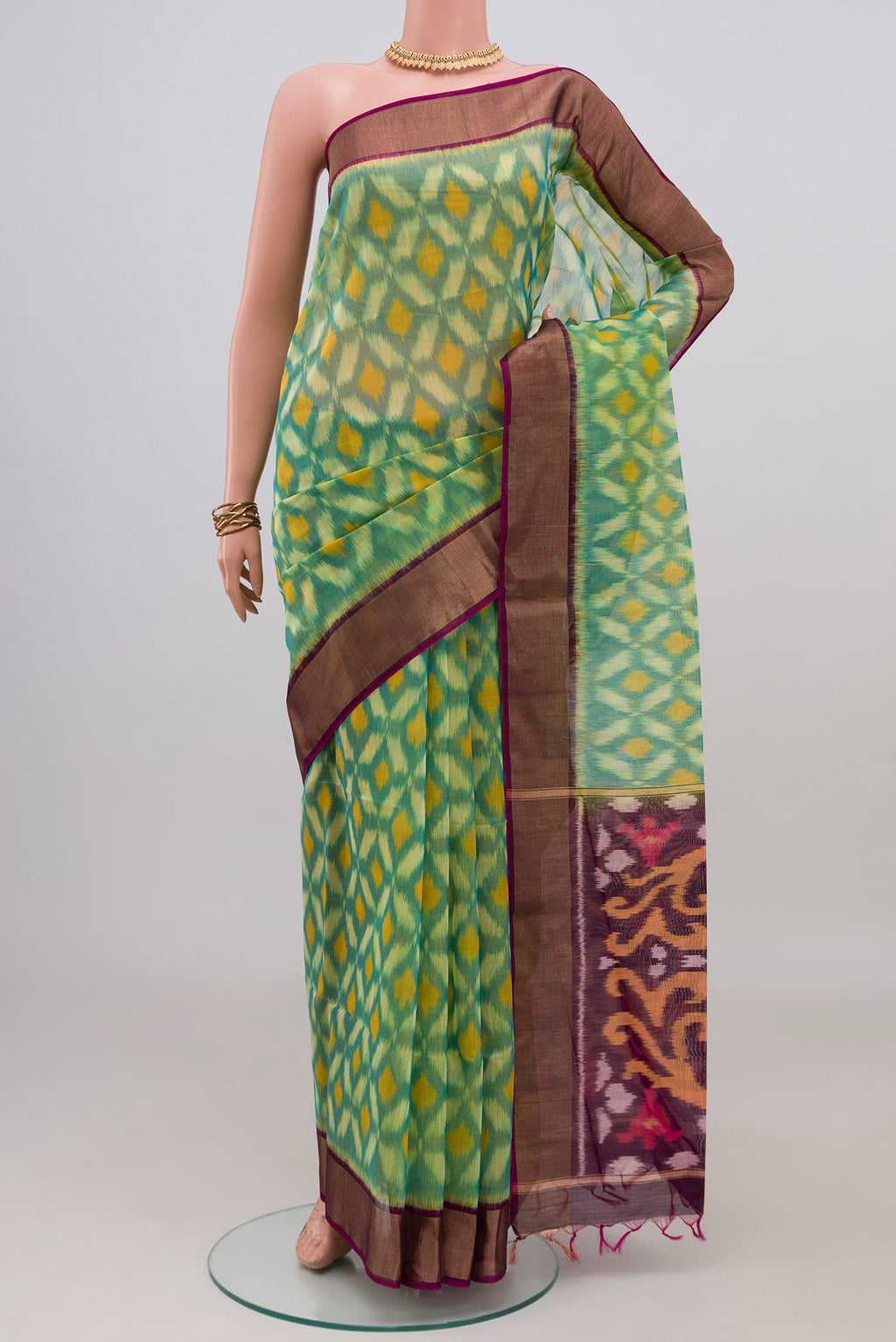 Light Green Silk Cotton Saree with Ikat design on the body and Zari Border.  displayed on a mannequin