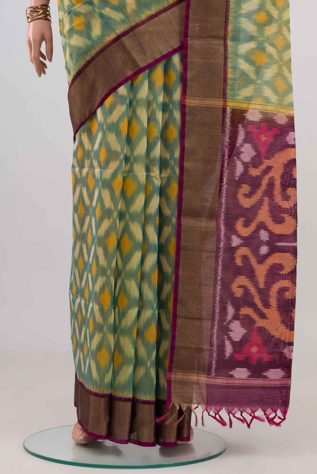 Pleats and pallu of Green Silk Cotton Saree with Ikat design on the body and Zari Border. 