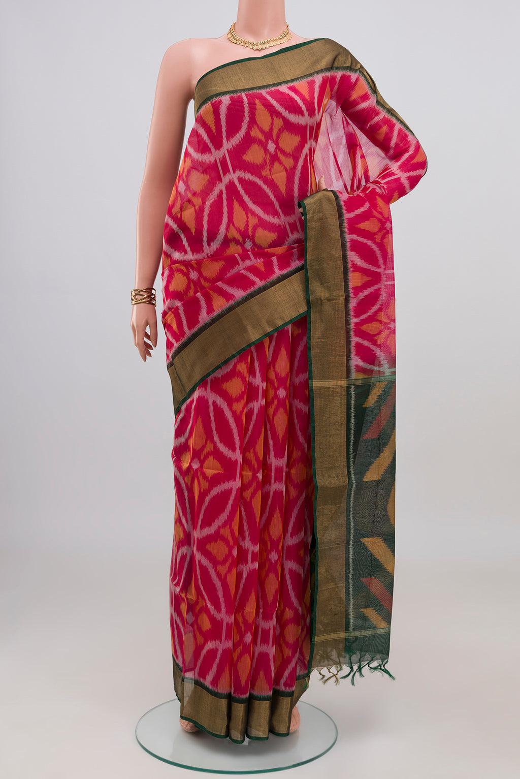 Pink Silk Cotton Saree with Ikat design on the body and Zari Border.  displayed on a mannequin