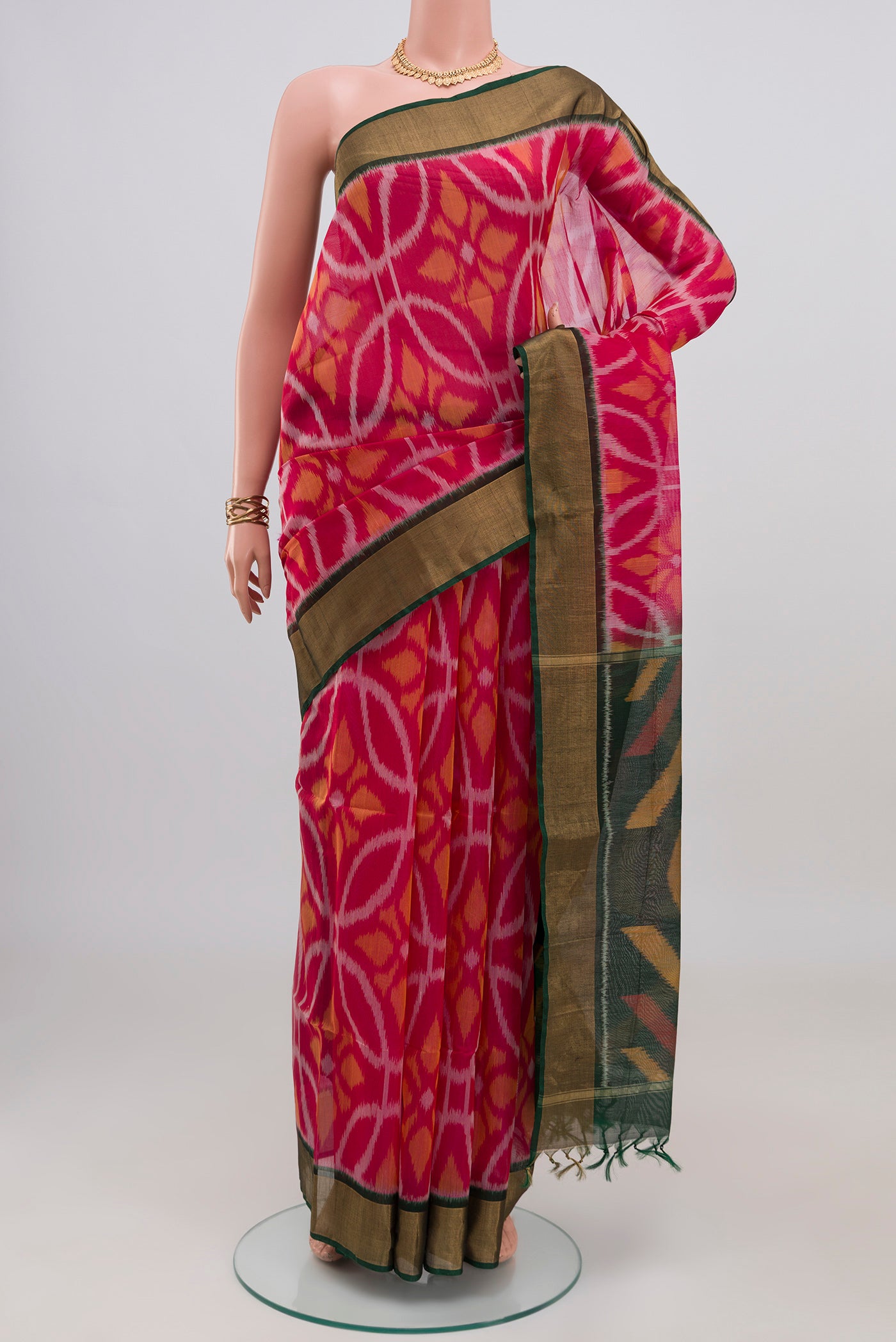 Pink Silk Cotton Saree with Ikat design on the body and Zari Border.  displayed on a mannequin