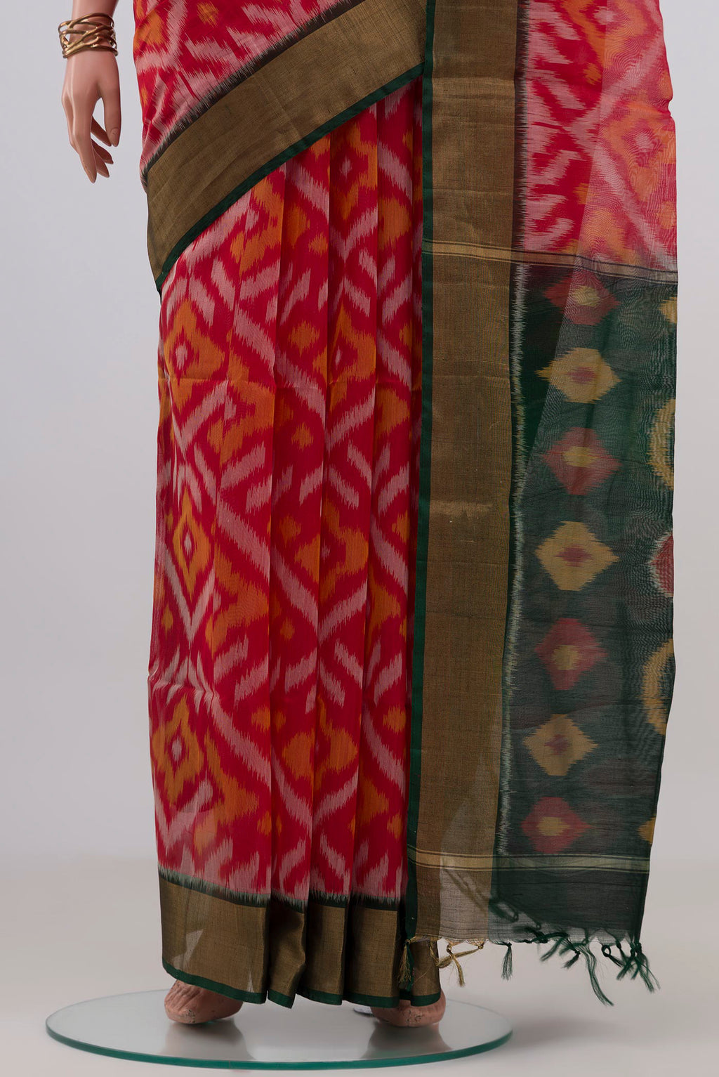Pleats and pallu of Red Silk Cotton Saree with Ikat design on the body and Zari Border. 