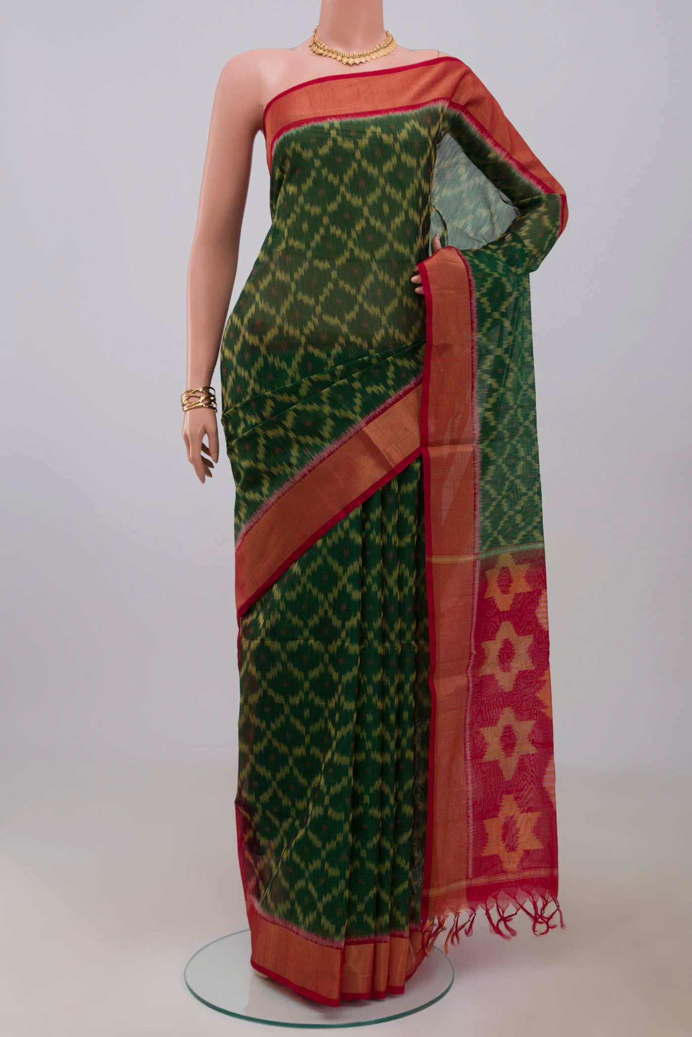 Green Silk Cotton Saree with Ikat Print on the body and Zari Border.  displayed on a mannequin