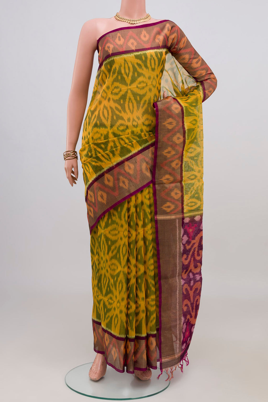 Yellow Silk Cotton Saree with Ikat design on the body and Zari Border.  displayed on a mannequin