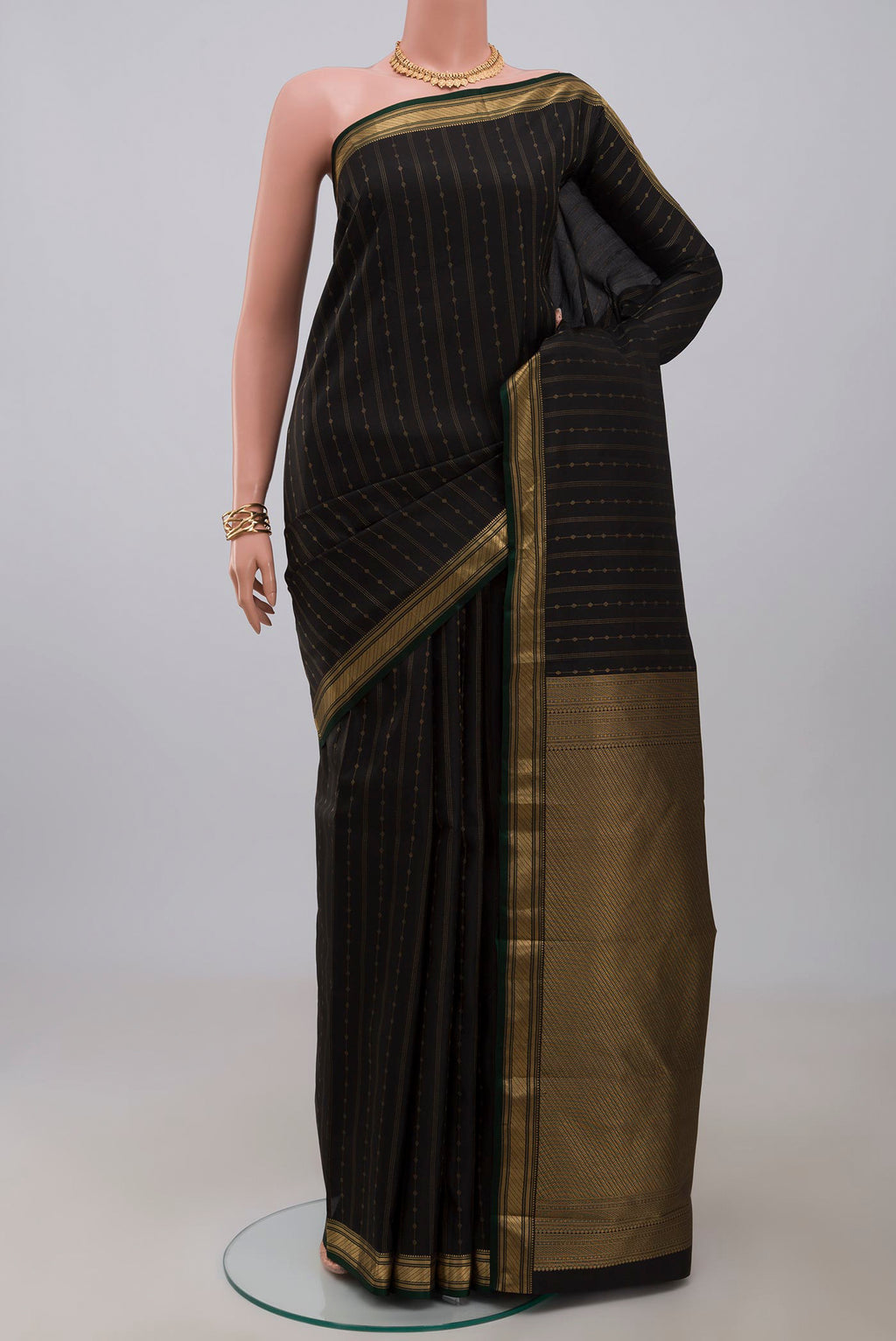 Black Kanchipuram Silk Saree with Zari Butta on the body and Zari Border.  displayed on a mannequin