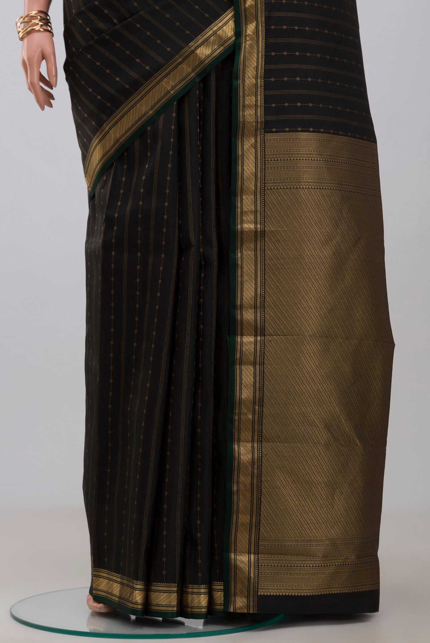 Pleats and pallu of Black Kanchipuram Silk Saree with Zari Butta on the body and Zari Border. 
