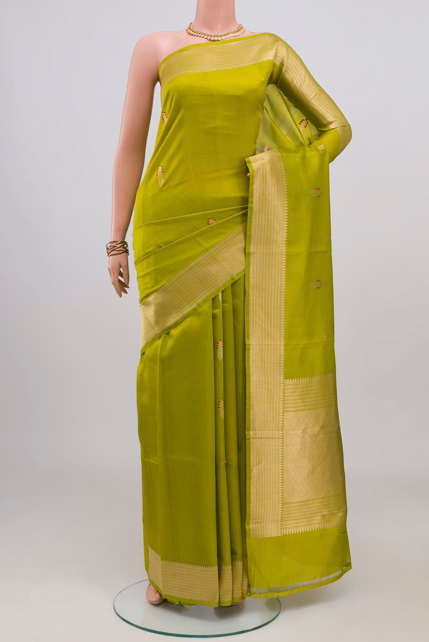 Parrot Green Banarasi Katan Silk Saree with Zari Butta on the body and Fancy Border.  displayed on a mannequin