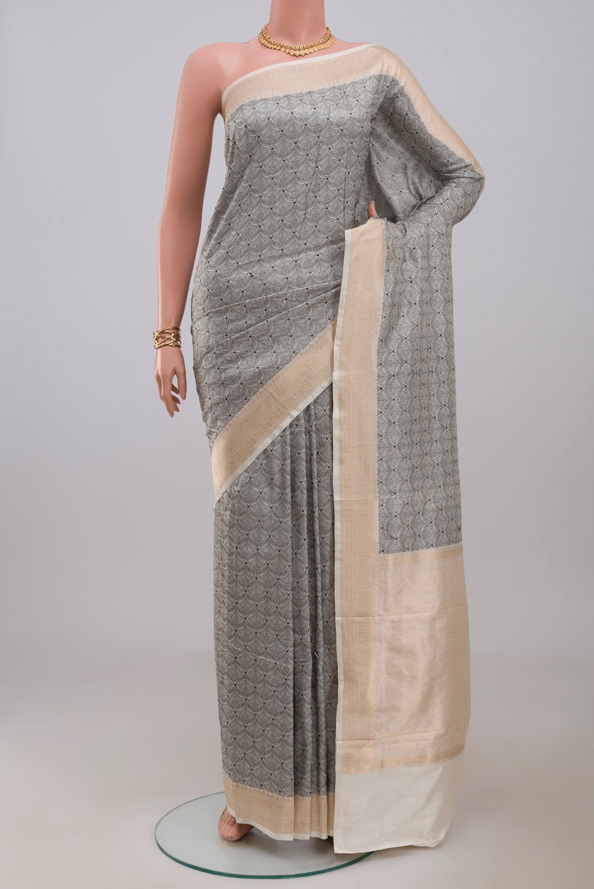 Cream Banarasi Katan Silk Saree with Jacquard design on the body and Zari Border.  displayed on a mannequin