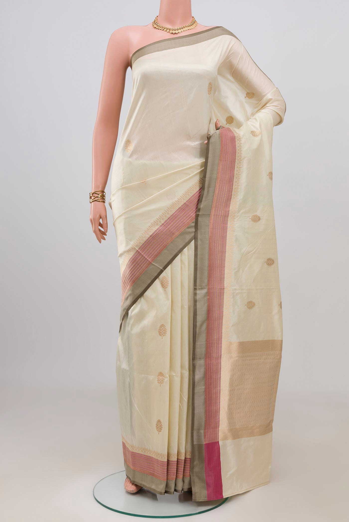Cream Banarasi Katan Silk Saree with Zari Butta on the body and Zari Border.  displayed on a mannequin