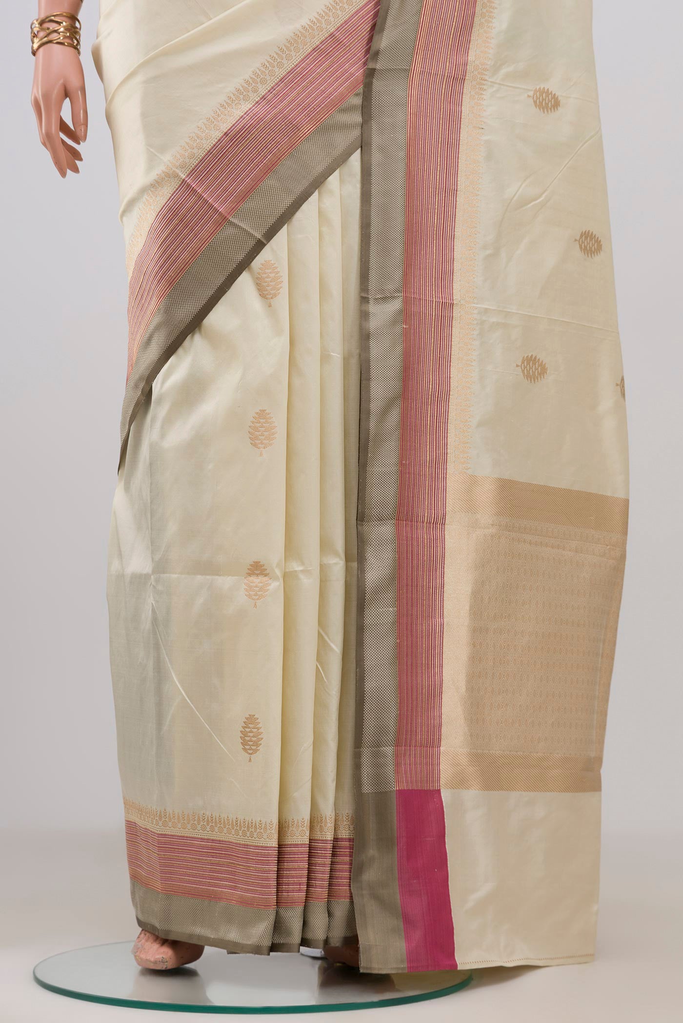 Pleats and pallu of Cream Banarasi Katan Silk Saree with Zari Butta on the body and Zari Border. 