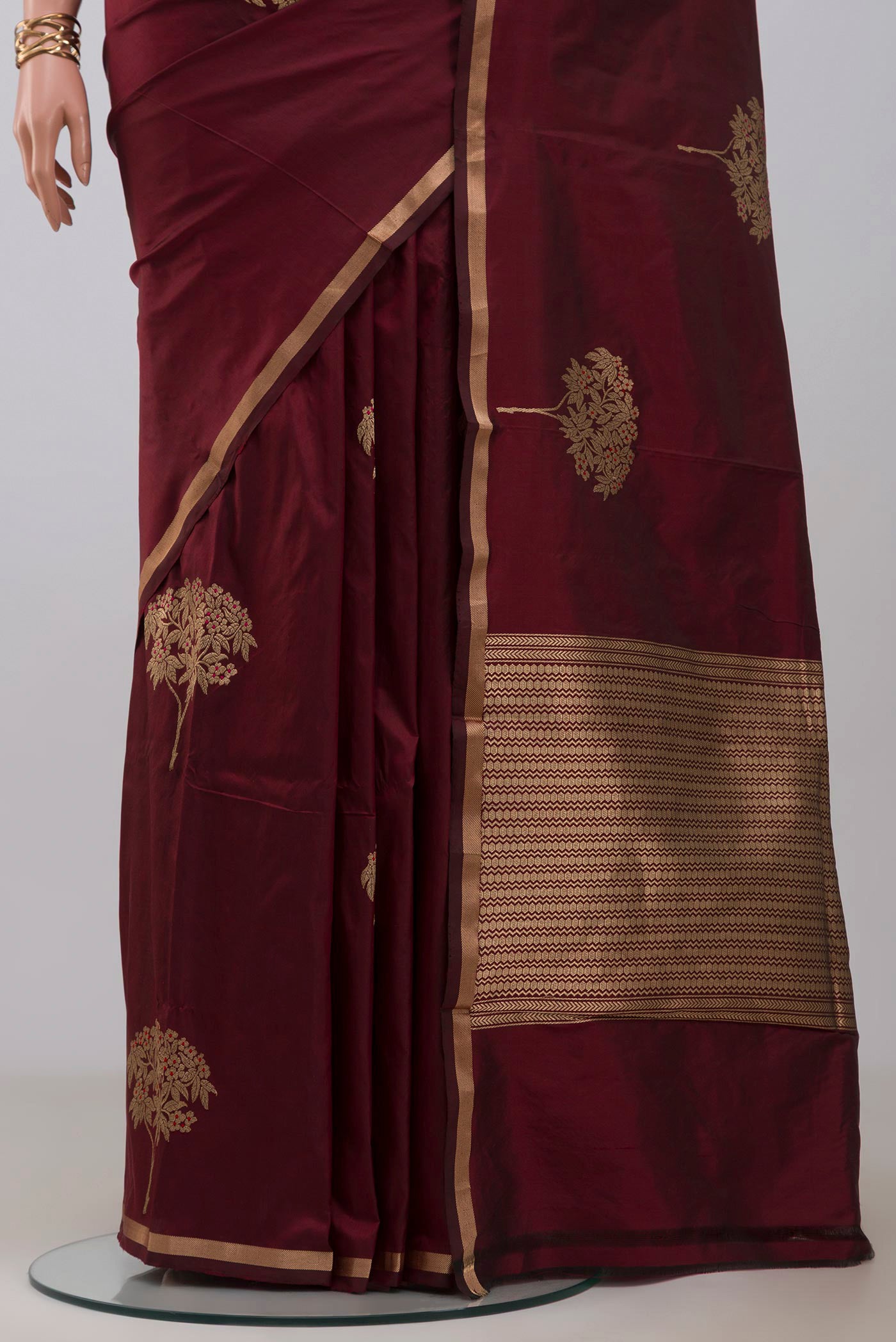 Pleats and pallu of Maroon Banarasi Katan Silk Saree with Zari Butta on the body and Thin Zari Line. 