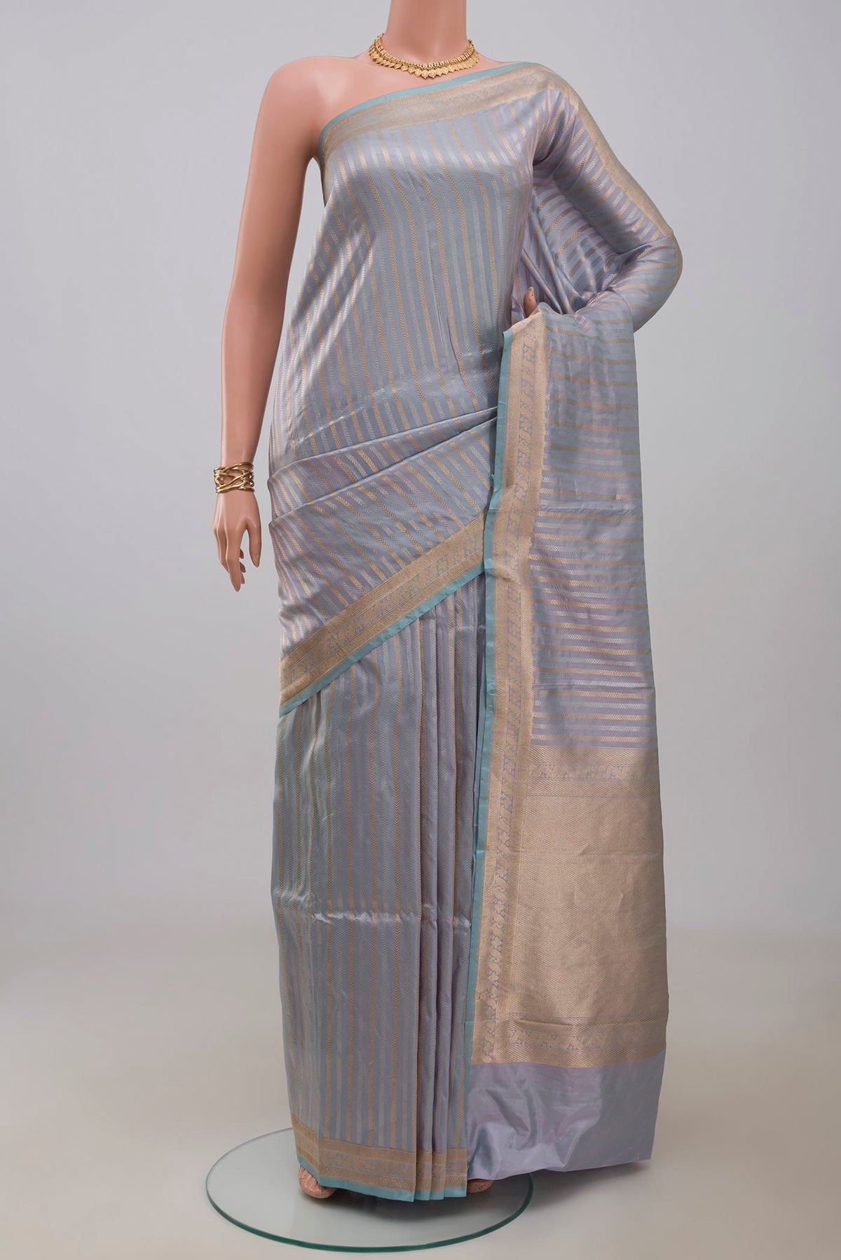 Light Blue Banarasi Katan Silk Saree with Stripes on the body and Zari Border.  displayed on a mannequin