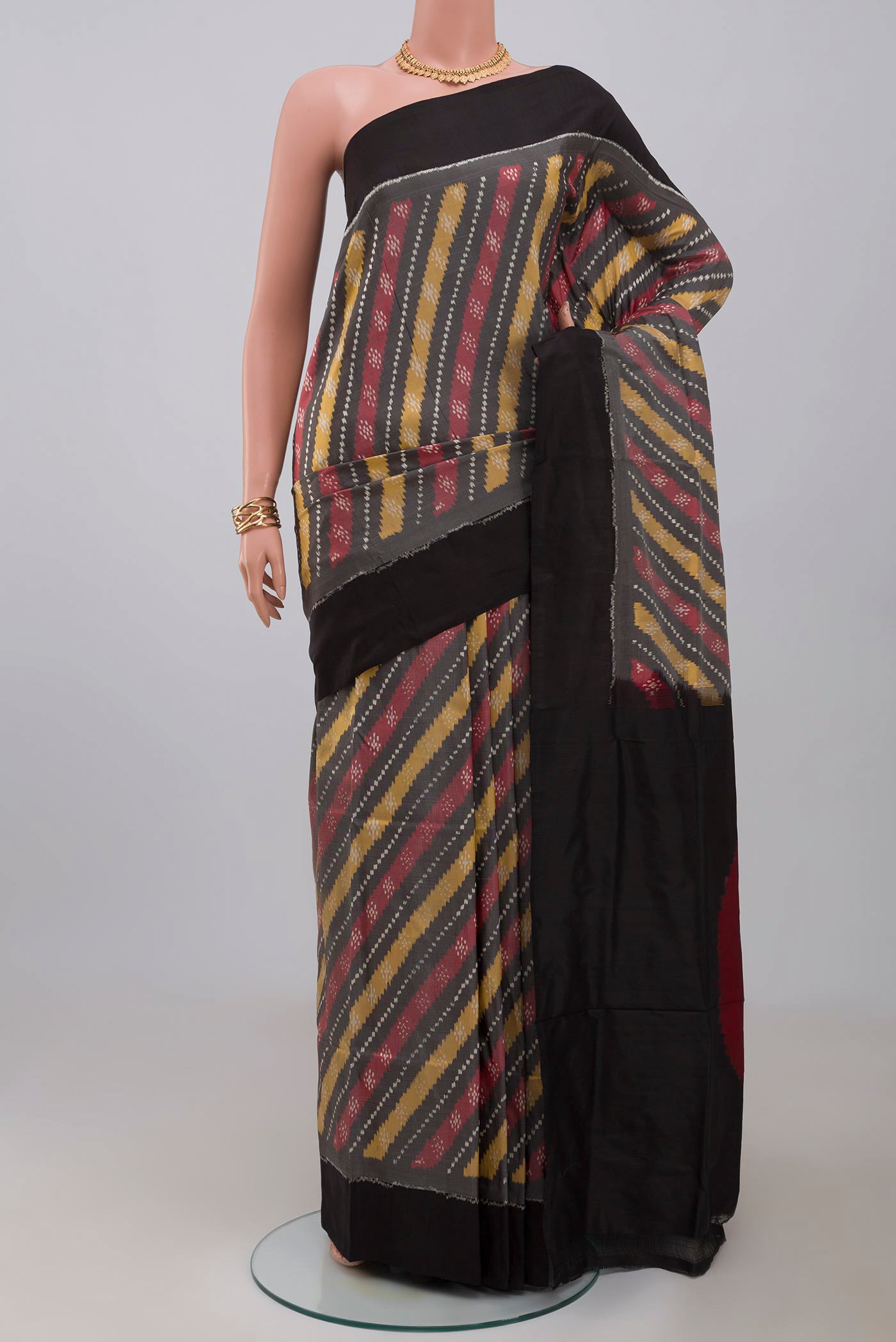Grey Pochampally Silk Saree with Ikat design on the body and Plain Border.  displayed on a mannequin