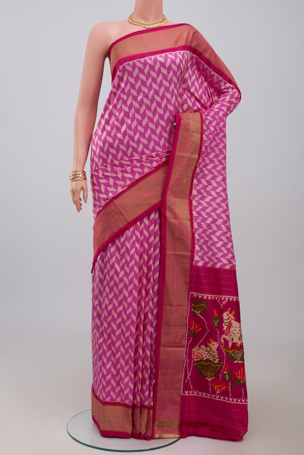 Pink Pochampally Silk Saree with Ikat design on the body and Zari Border.  displayed on a mannequin