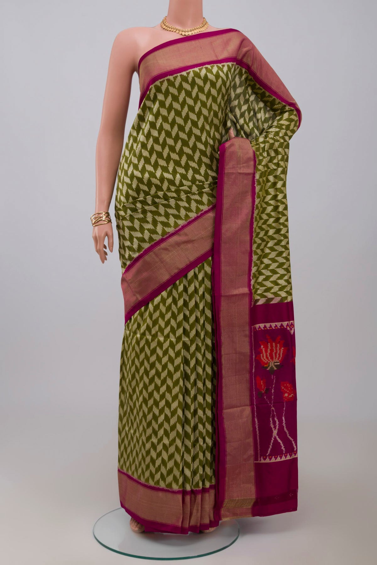 Green Pochampally Silk Saree with Ikat design on the body and Zari Border.  displayed on a mannequin