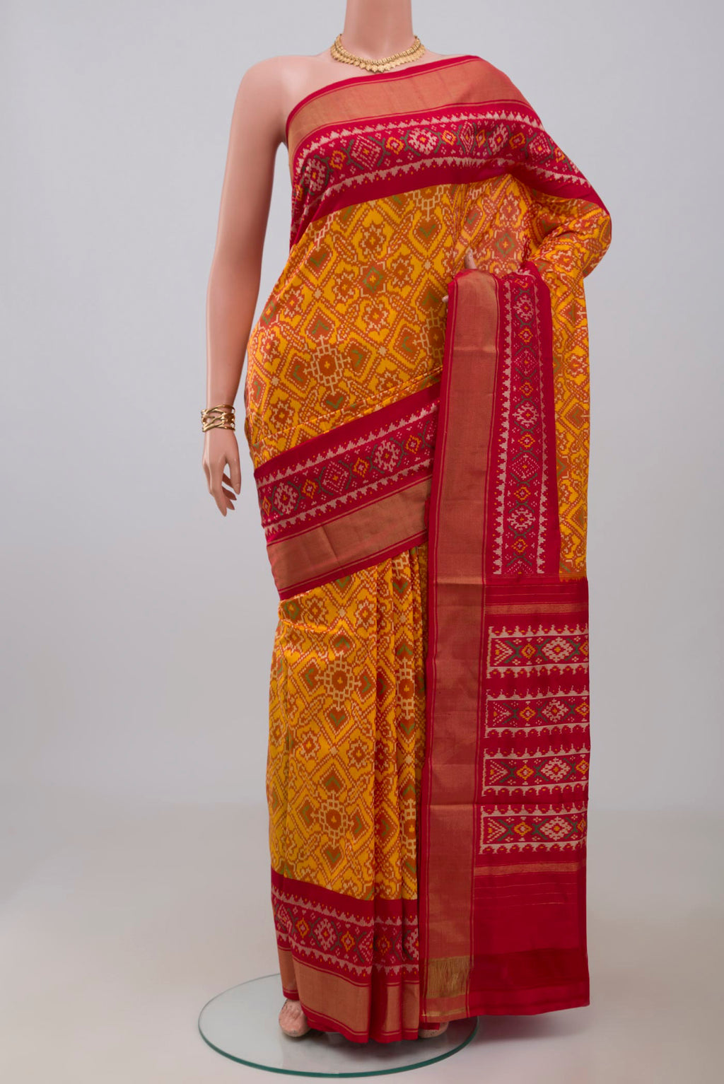 Yellow Pochampally Silk Saree with Ikat design on the body and Zari Border.  displayed on a mannequin