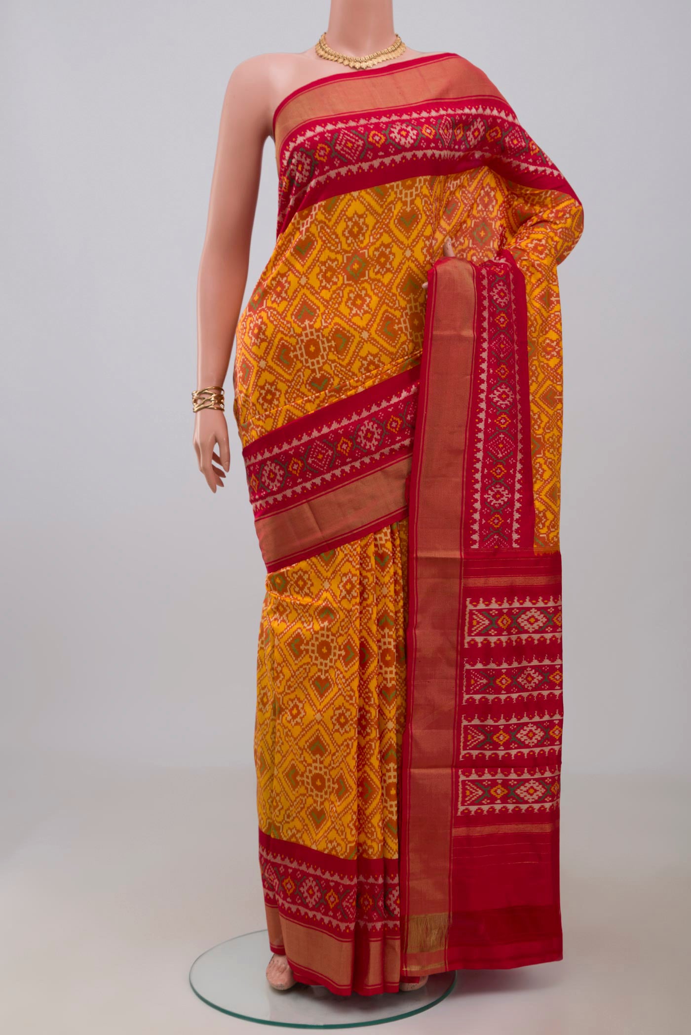 Yellow Pochampally Silk Saree with Ikat design on the body and Zari Border.  displayed on a mannequin