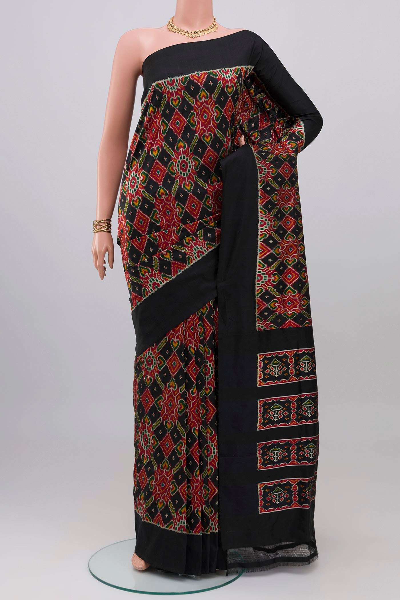 Black Pochampally Silk Saree with Ikat design on the body and Plain Border.  displayed on a mannequin