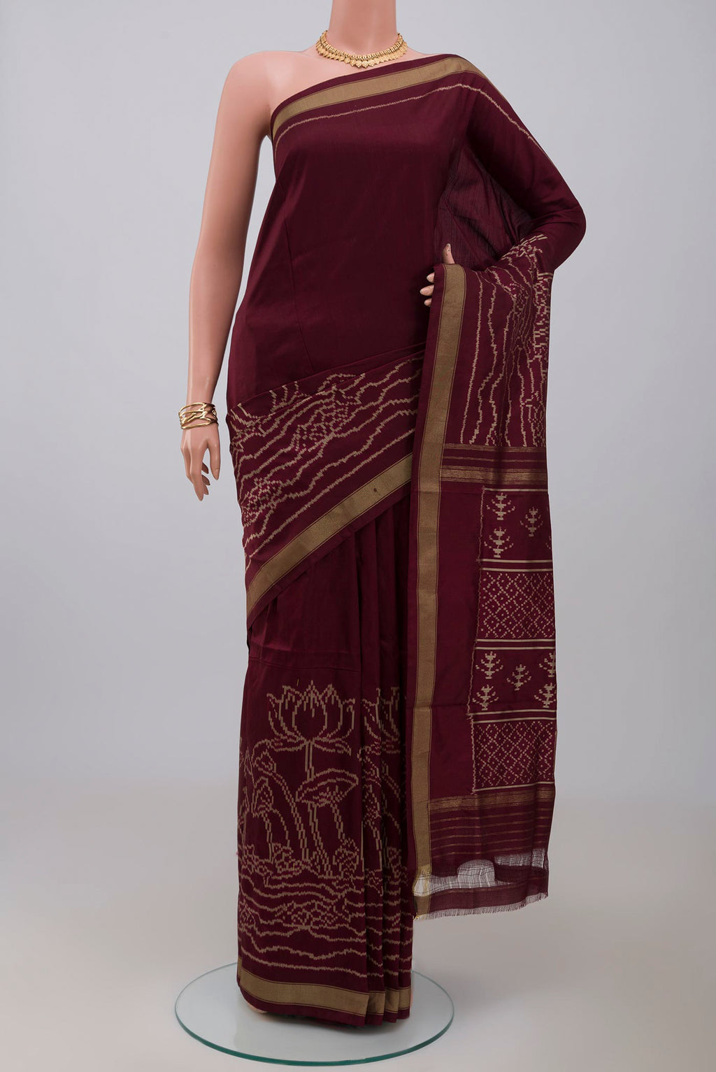 Brown Pochampally Silk Saree with Ikat design on the body and Zari Border.  displayed on a mannequin