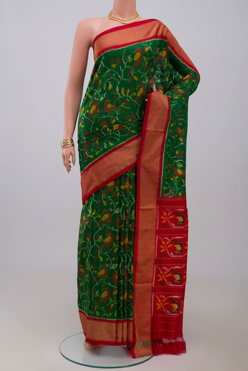Green Pochampally Silk Saree with Ikat design on the body and Zari Border.  displayed on a mannequin