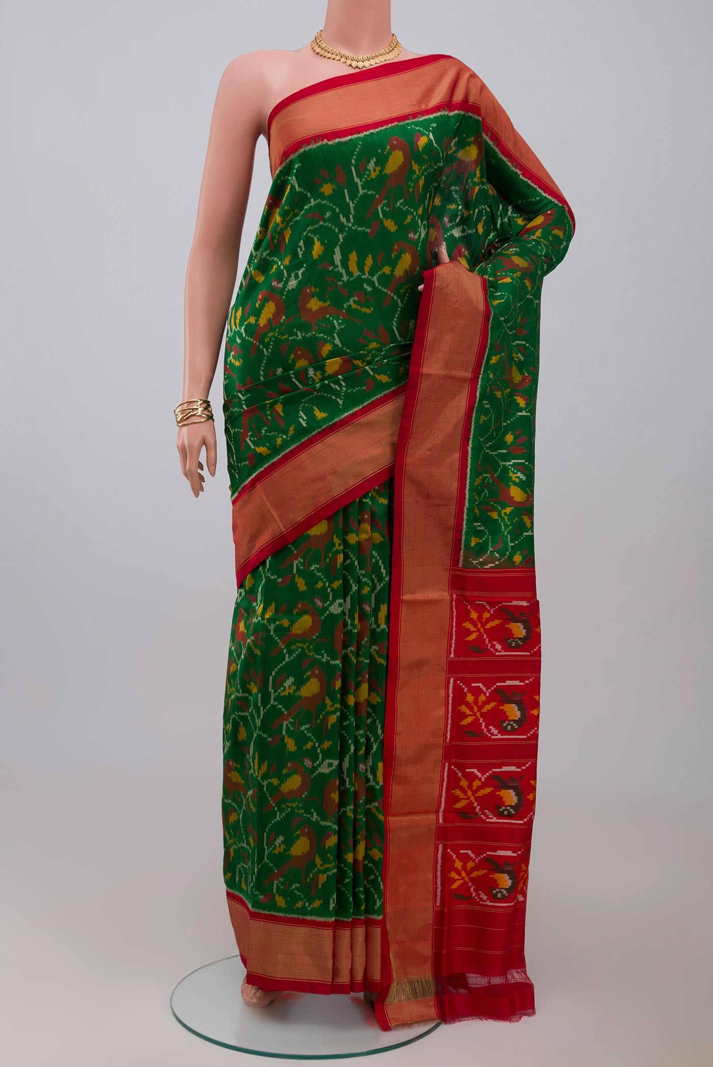Green Pochampally Silk Saree with Ikat design on the body and Zari Border.  displayed on a mannequin