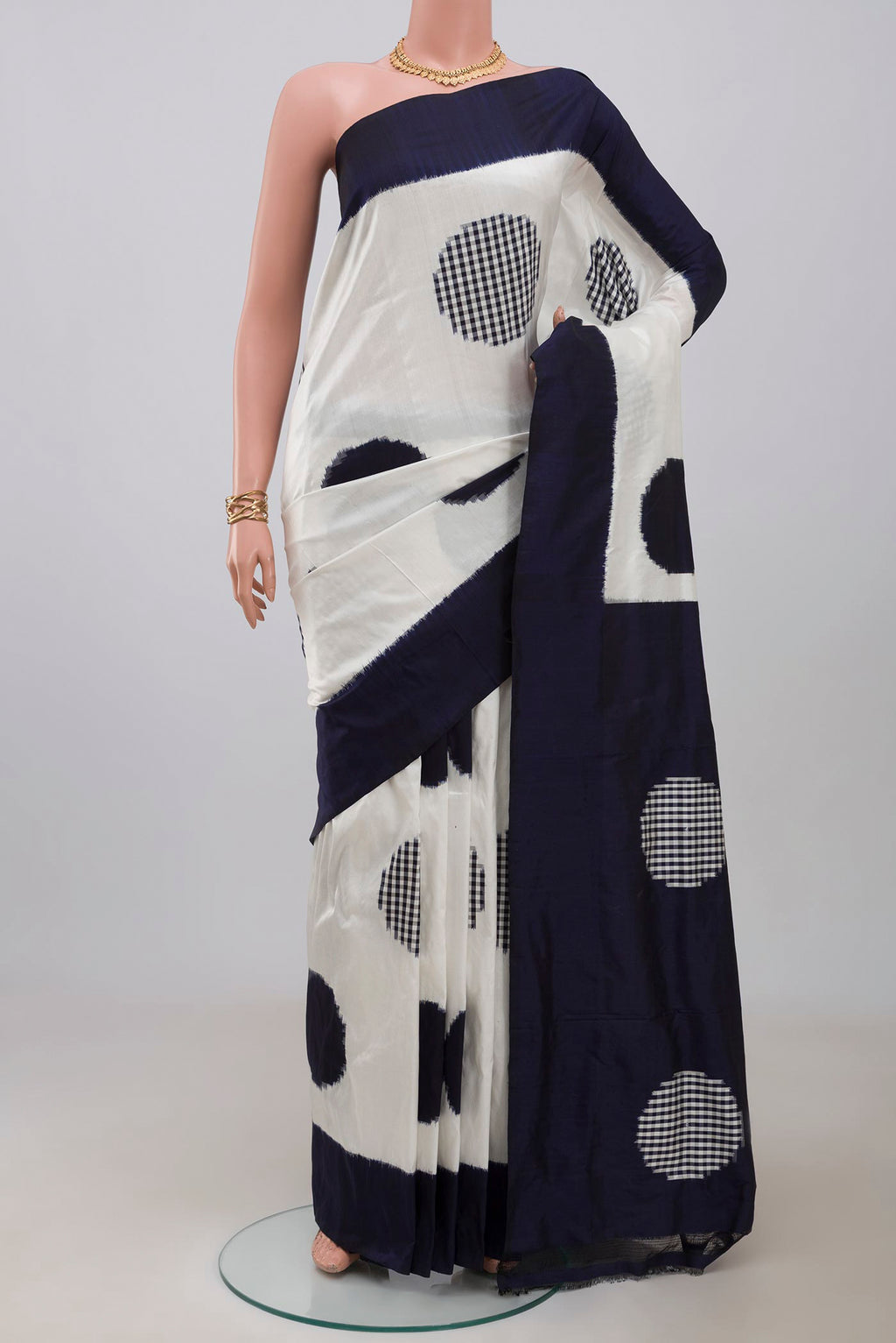 White Pochampally Saree with Ikat design on the body and Plain Border.  displayed on a mannequin