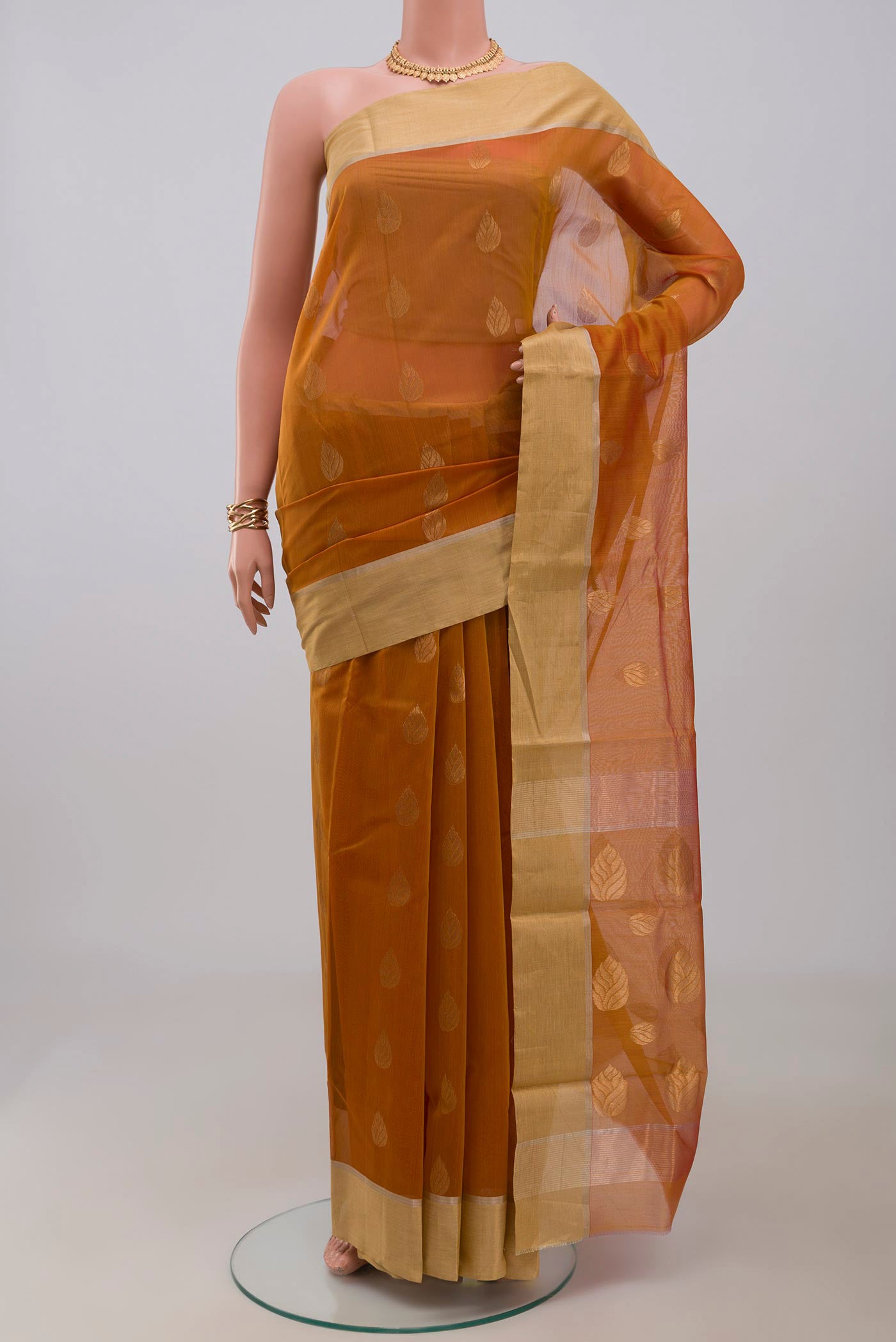 Mustard Chanderi Silk Cotton Saree with Zari Butta on the body and Zari Border.  displayed on a mannequin
