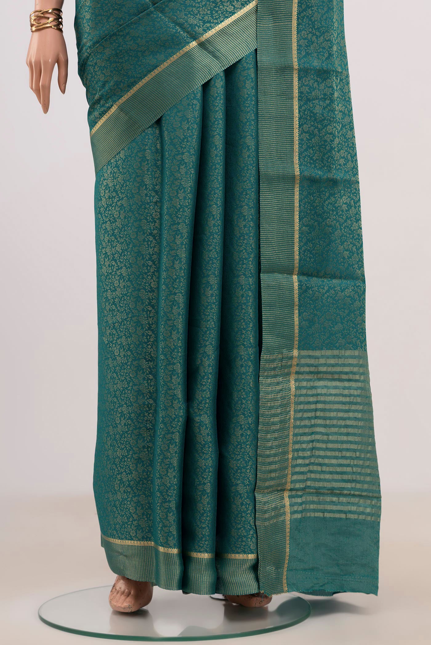 Pleats and pallu of Peacock Blue Mysore Georgette Saree with Fancy on the body and Zari Border. 
