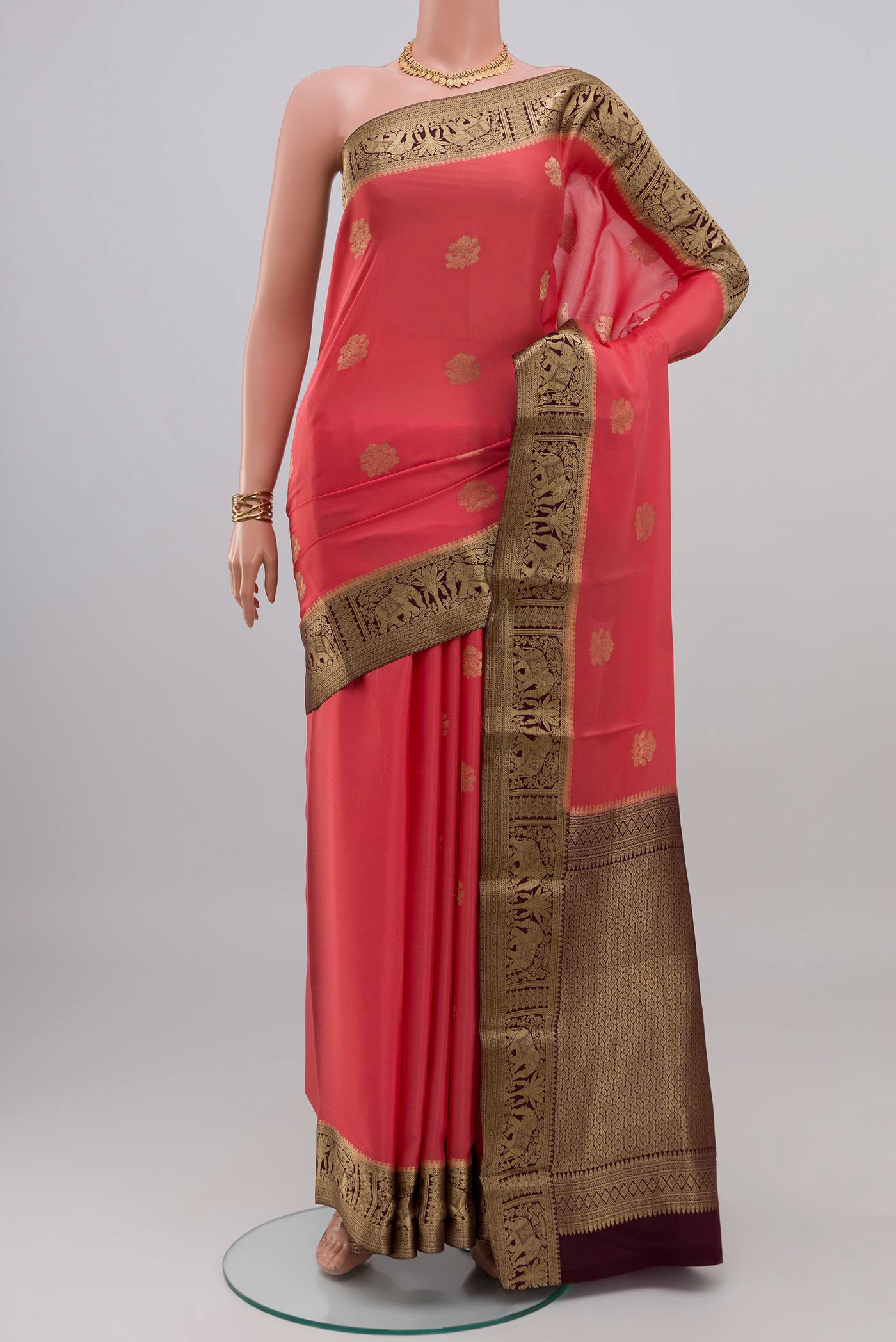 Coral Mysore Crepe Saree with Zari Butta on the body and Zari Border.  displayed on a mannequin