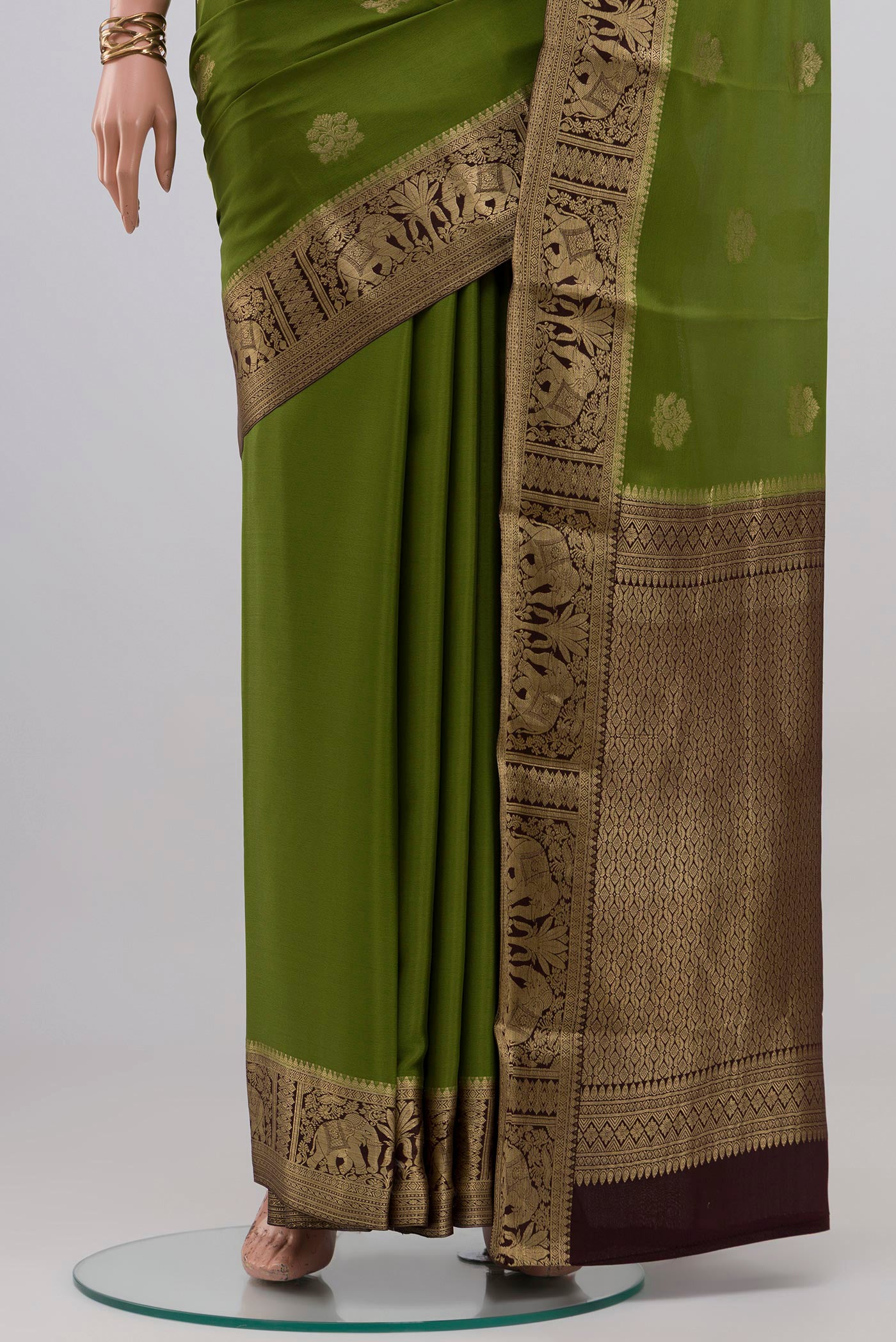 Pleats and pallu of Mehandi Green Mysore Crepe Saree with Zari Butta on the body and Zari Border. 