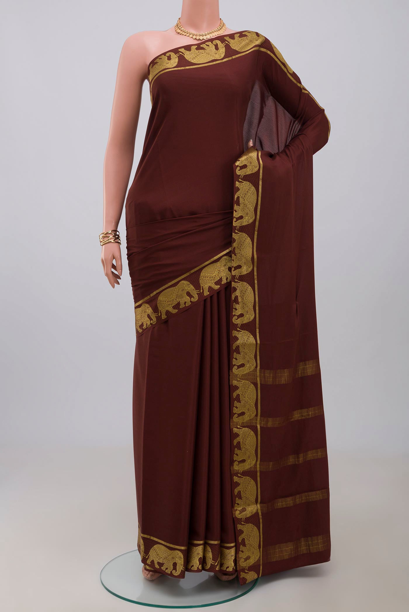 Brown Crepe Saree with Plain Body and Fancy Border.  displayed on a mannequin