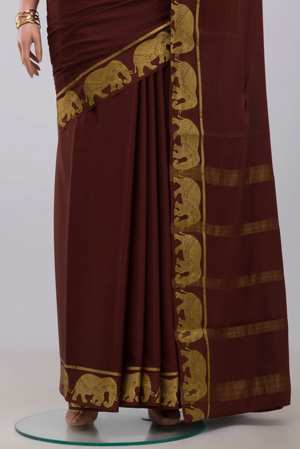 Pleats and pallu of Brown Crepe Saree with Plain Body and Fancy Border. 