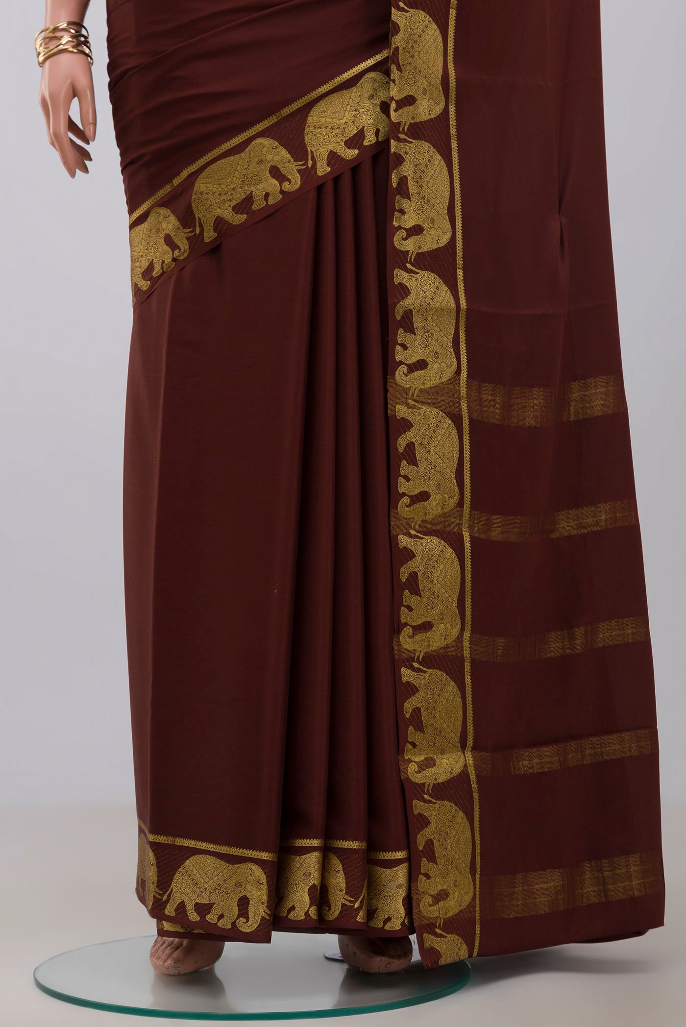 Pleats and pallu of Brown Crepe Saree with Plain Body and Fancy Border. 