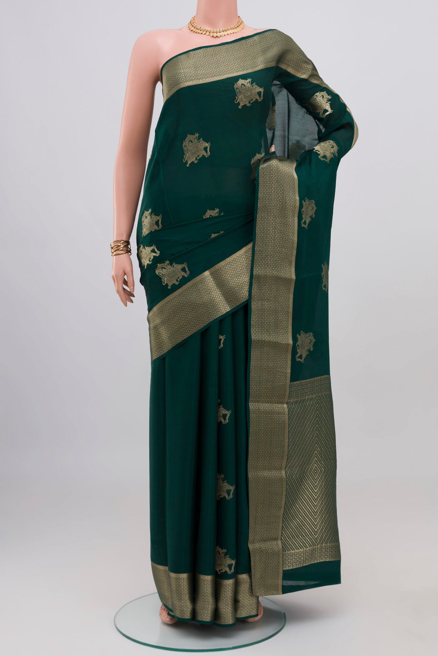 Bottle Green Mysore Crepe Saree with Zari Butta on the body and Zari Border.  displayed on a mannequin